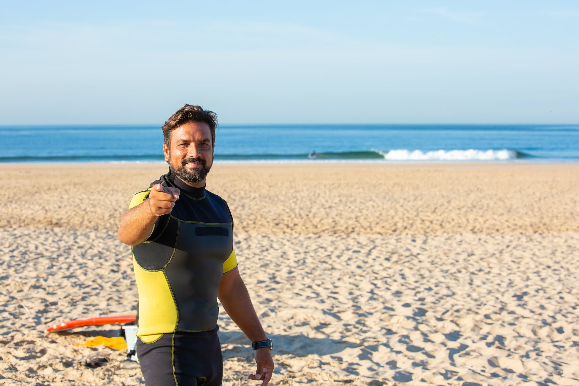 man in wetsuit pointing finger at camera