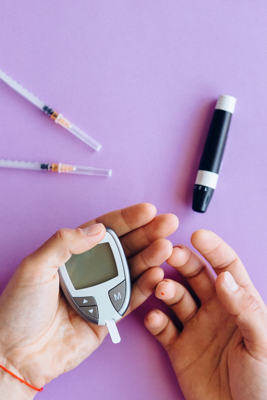hands holding glucose meter near the insulin