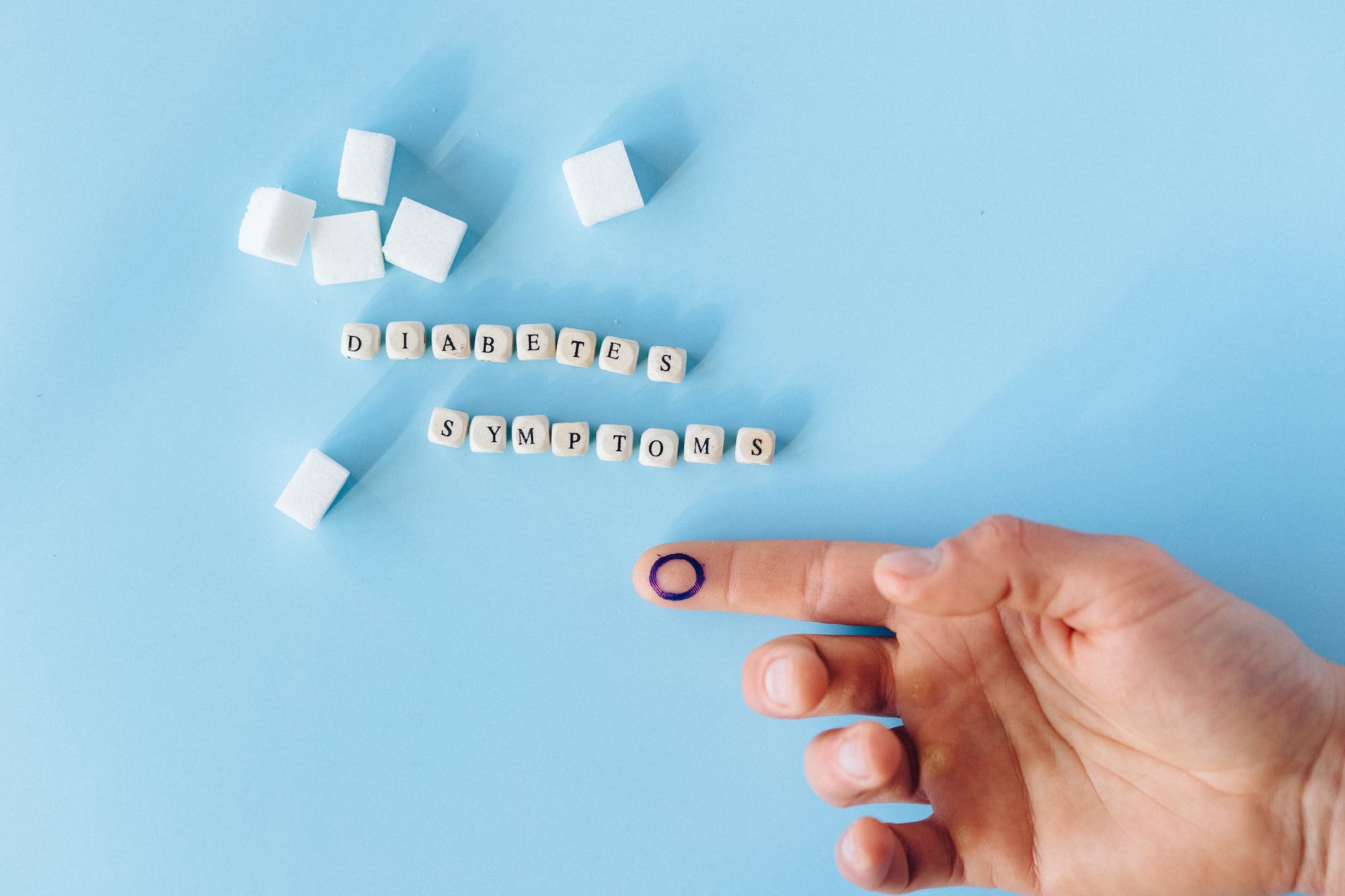 hand of a person near letter blocks on a light blue background