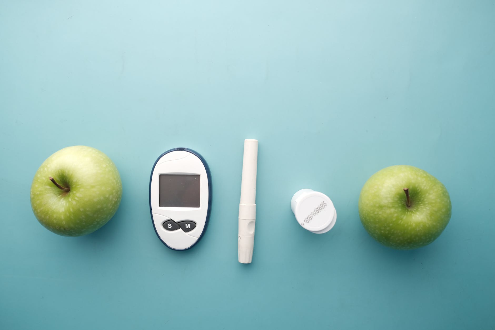 blood glucose meter kit between green apples