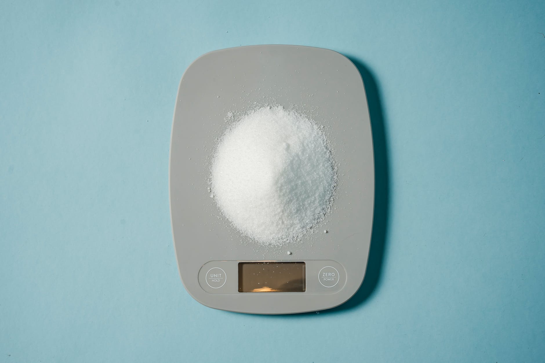 electronic scales with heap of sugar