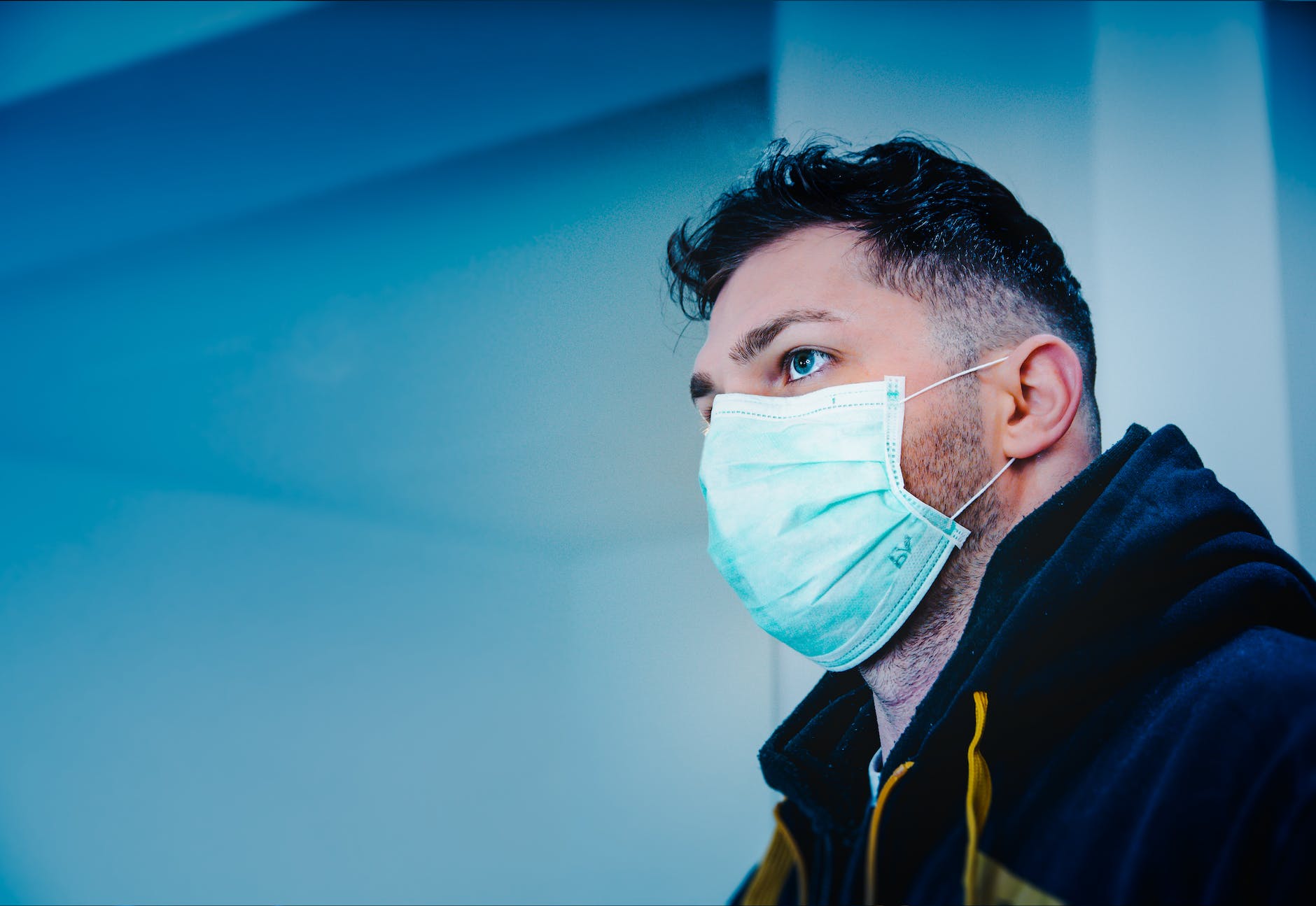 man in black and yellow jacket with face mask